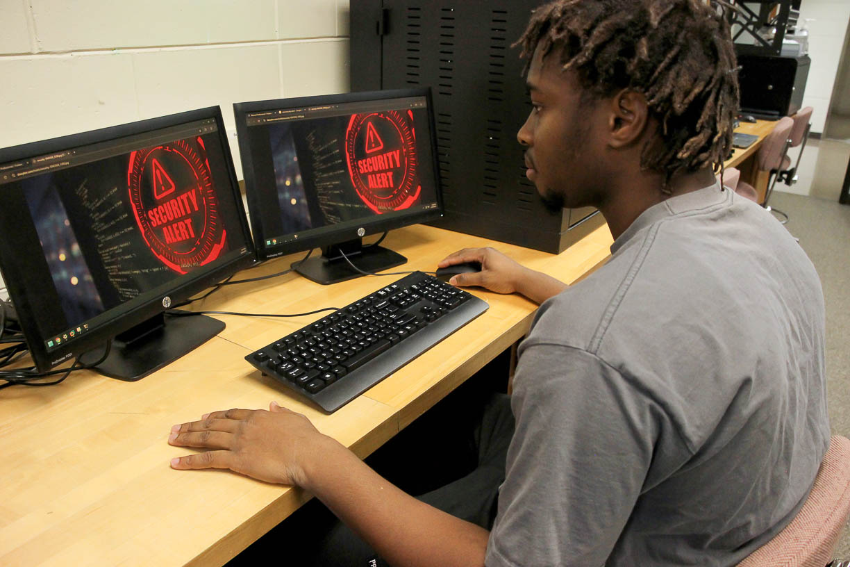 Student sitting in front of two computer screens